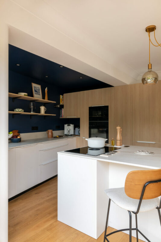 une cuisine bois et bleue, ouverte avec un ilot central 