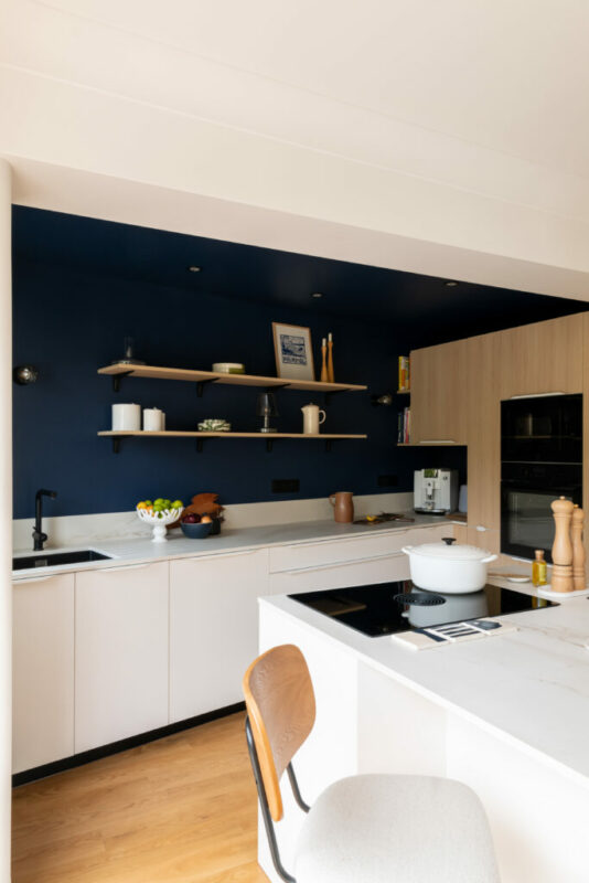 une cuisine bois et bleue, ouverte avec un ilot à nantes  central 