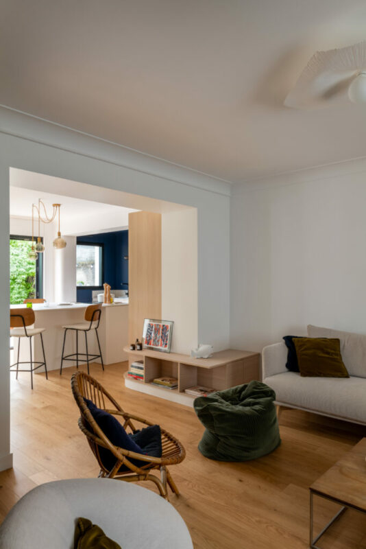 une cuisine bois et bleue, ouverte avec un ilot central  et un meuble tele qui fait la jonction une renovation sur mesure milimetrée 